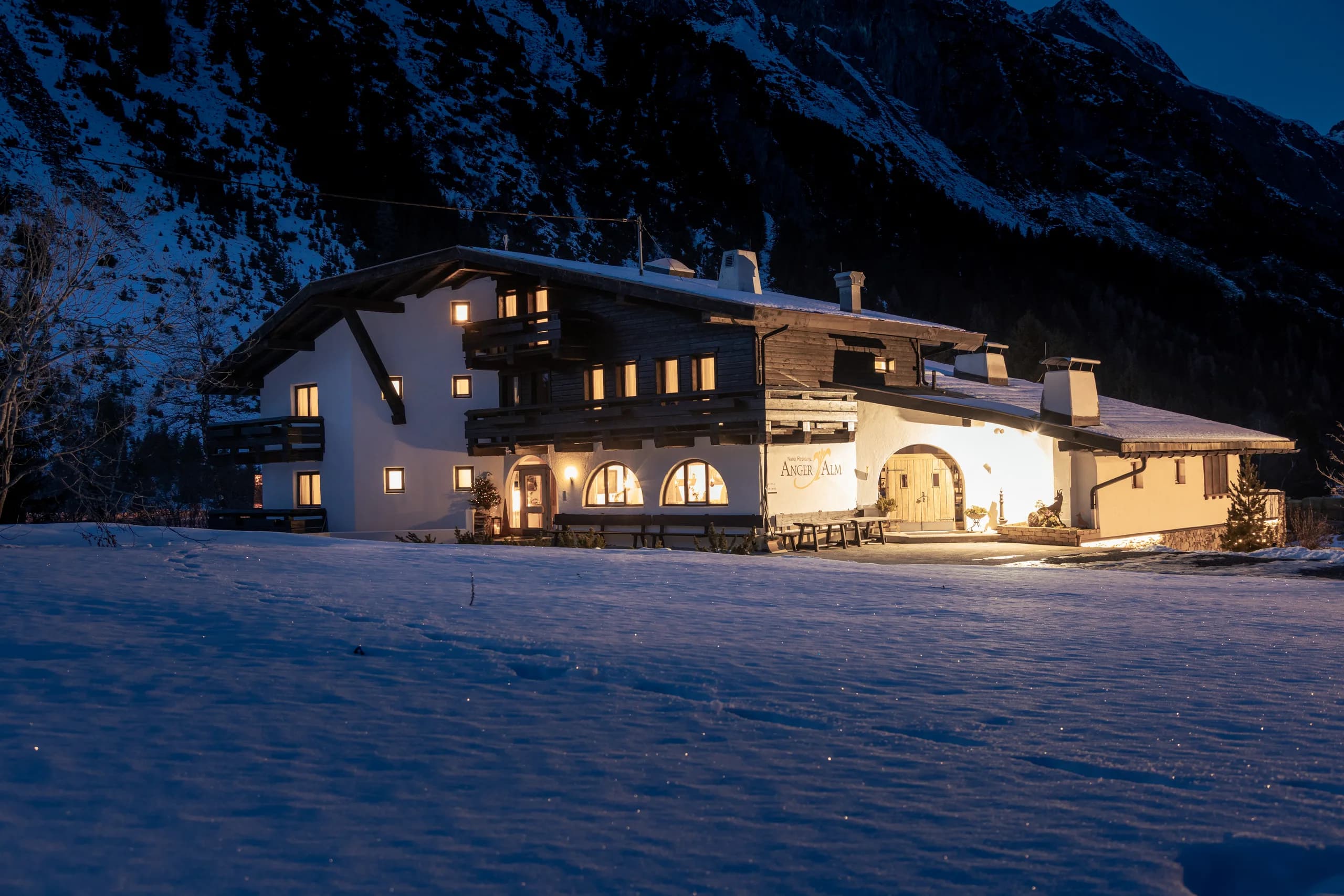 Gemütlich beleuchtetes Hotel der Natur Residenz Anger Alm am Abend